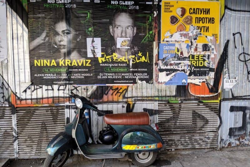 Abgerissene Poster und Graffiti über einem Motorroller