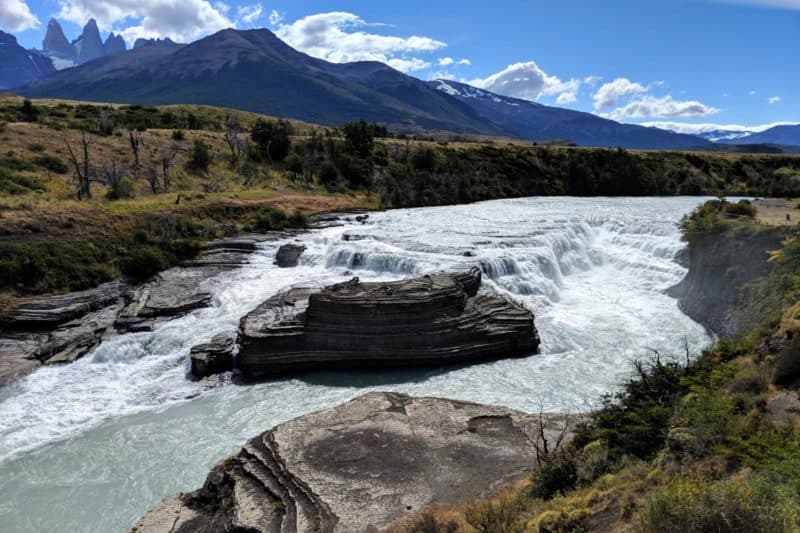 Mehrstufiger Wasserfall mit den Torres del Paine im Hintergrund
