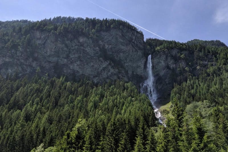 Der Jungfernsprung-Wasserfall wird von Bergen und Bäumen gerahmt.