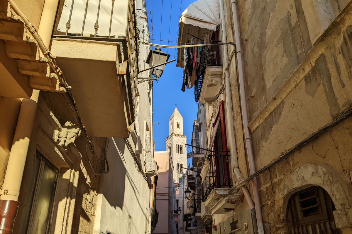 Altstadtgasse in Bari mit Kirchturm, Balkonen und Wäscheleinen