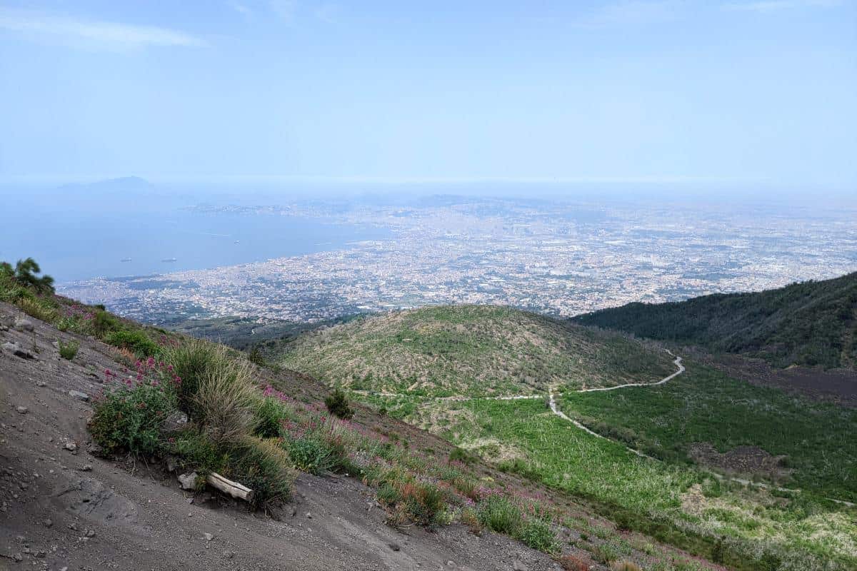 Hang des Vesuvs mit grauer Vulkanerde vor einem Panorama über Neapel und den Golf