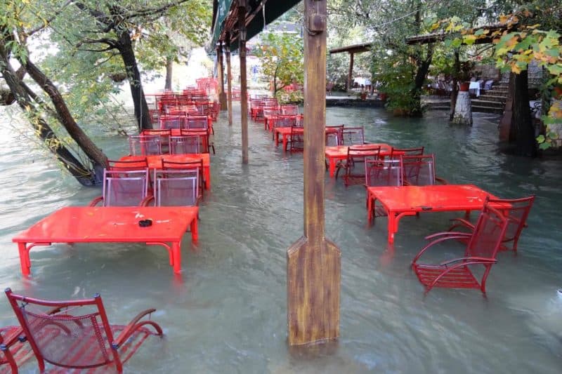 Überfluteter Gastgarten mit roten Tischen und Stühlen