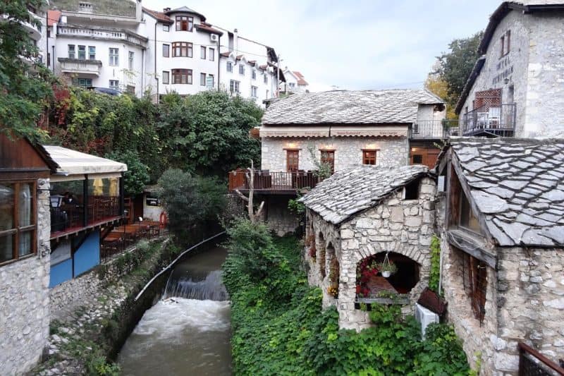 Altstadt von Mostar mit kleinen, steinernen Häusern und einem Bach