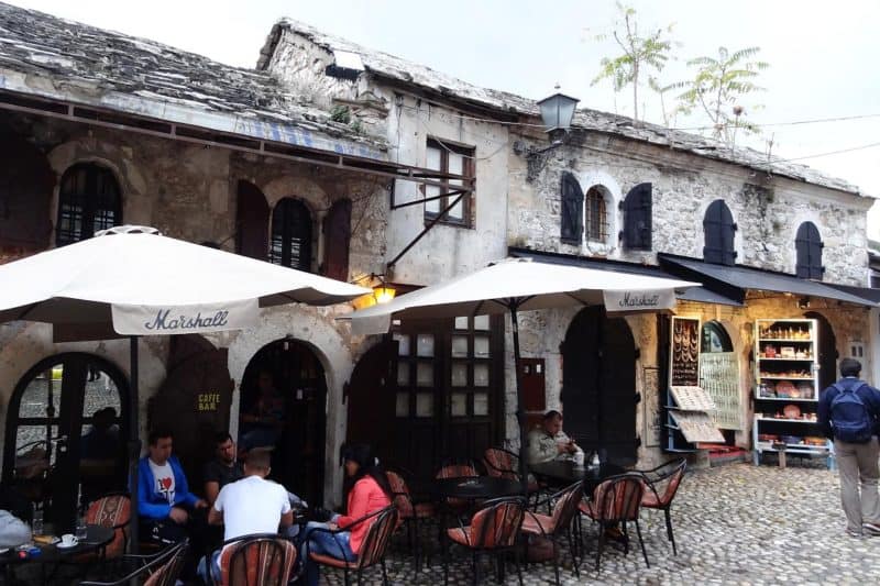 Menschen sitzen auf der Terrasse eines Straßencafés in Mostar