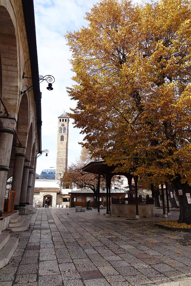 Innenhof der Gazi-Husrev-Beg-Moschee in Sarajevo mit herbstlichen Bäumen