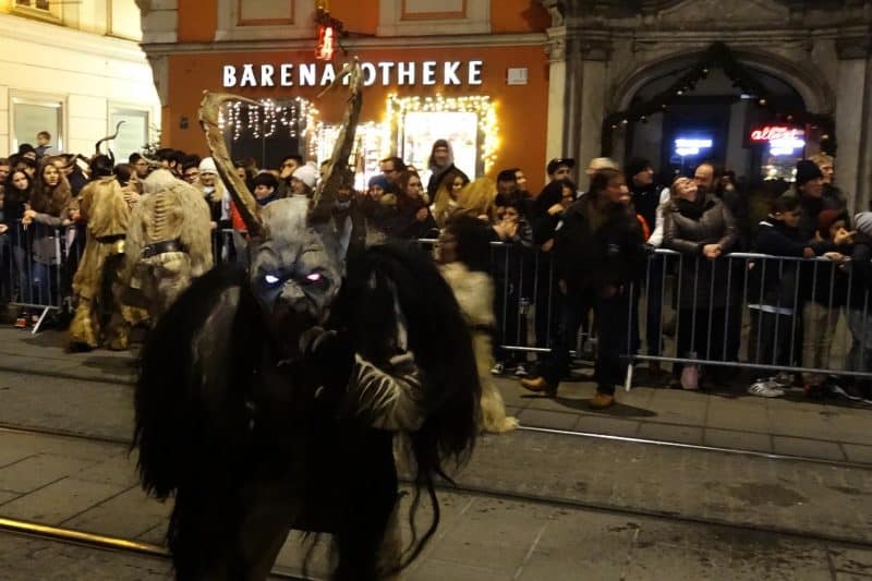 Perchte mit Hörnern und leuchtenden Augen beim Perchtenlauf in Graz