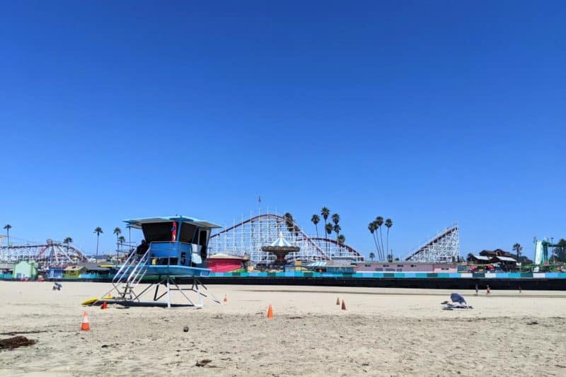 Life Guard Häuschen am Strand von Santa Cruz mit Achterbahn und Kettenkarussell des Santa Cruz Beach Boardwalks im Hintergrund