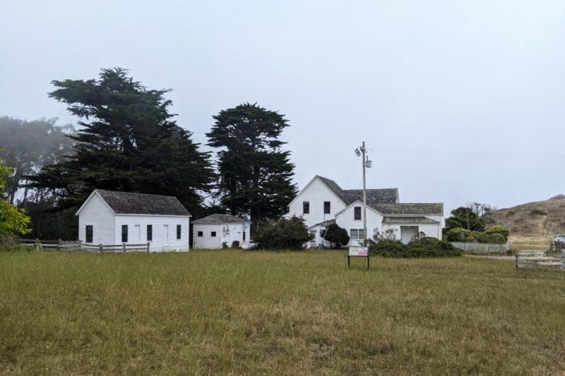 Weiße Farmgebäude der Pierce Point Ranch im Nebel