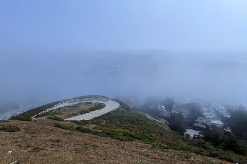 Twin Peaks Aussichtspunkt mit Nebel, durch den die Skyline von San Francisco leicht hervorschimmert