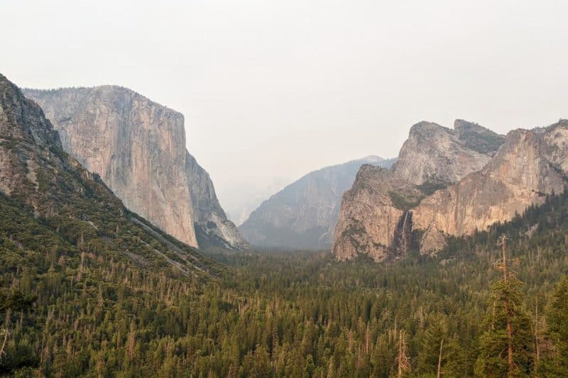 Tunnel View im Yosemite-Nationalpark mit El Capitan links im Vordergrund und Half Dome im diesigen Hintergrund