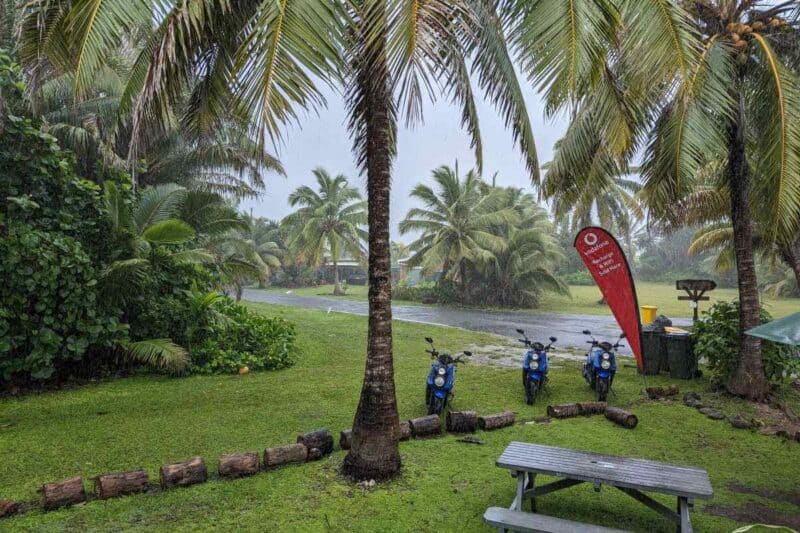 Verregneter Blick auf eine von Palmen gesäumte Straße in Arutanga auf Aitutaki
