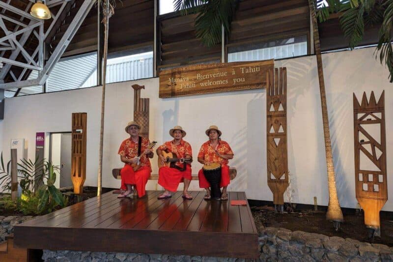 Eine polynesische Band spielt Willkommenslieder am Flughafen auf Papeete