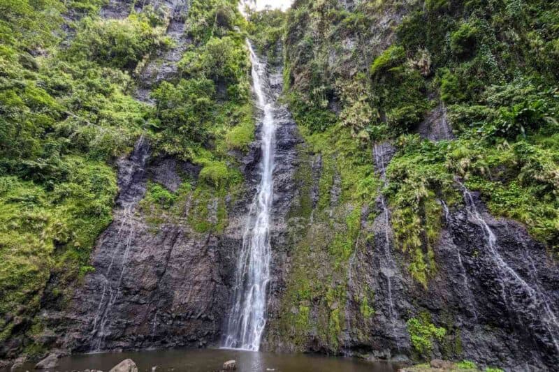 Ein Hauptwasserfall und mehrere Nebenfälle an einer moosbewachsenen Wand bei den Cascades de Faarumai auf Tahiti