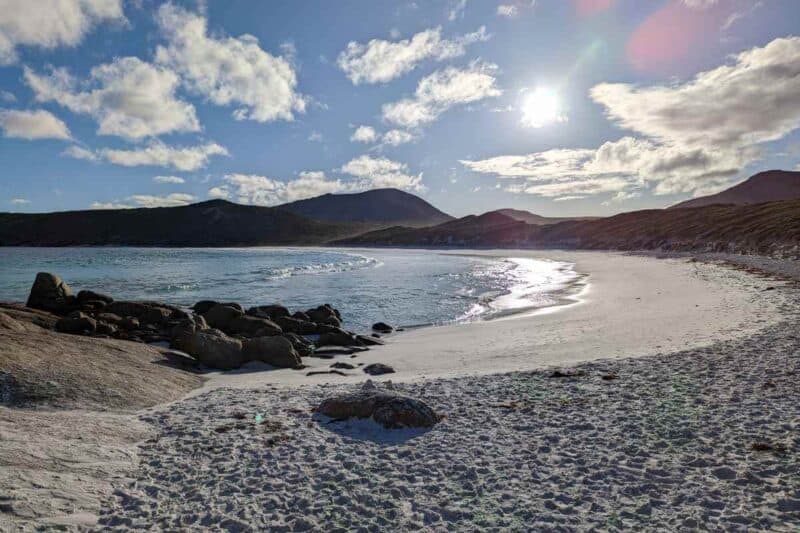 Von Hügeln umringte Bucht mit Felsbrocken im weißen Sand in der Hellfire Bay im Cape Le Grand National Park