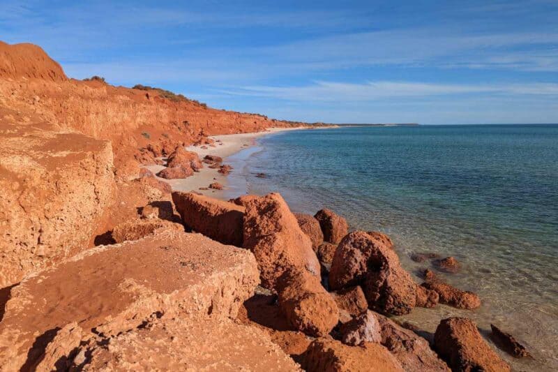 Leuchtend rote Felsen rahmen das blaue Meer im François Peron National Park