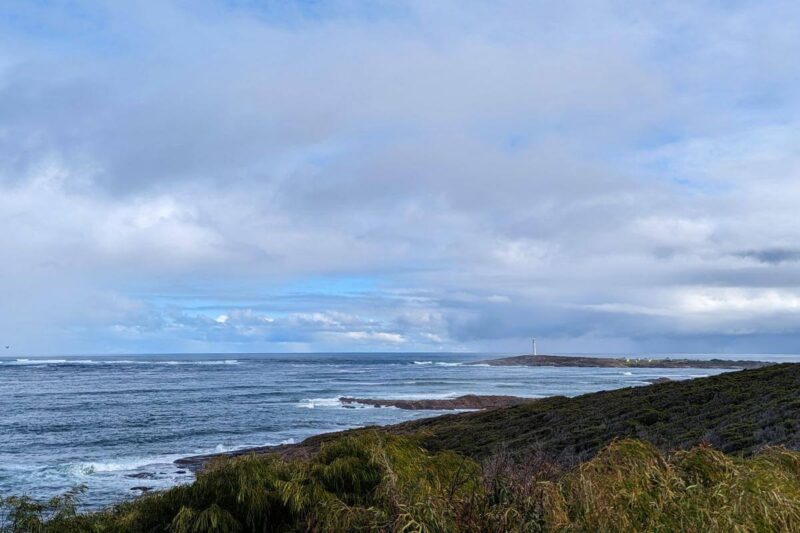 Küste des Leeuwin-Naturaliste-Nationalparks in Westaustralien mit weißem Leuchtturm im Hintergrund