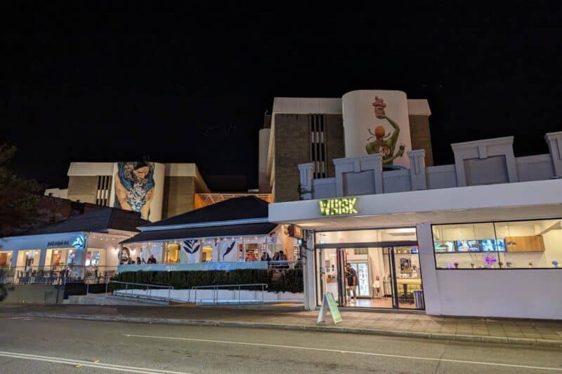 Nächtlich beleuchtete Straßenlokale in Northbridge mit Streetart im Hintergrund