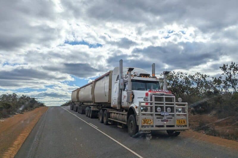 Ein dreigliedriger Road Train auf einer Landstraße in Westaustralien