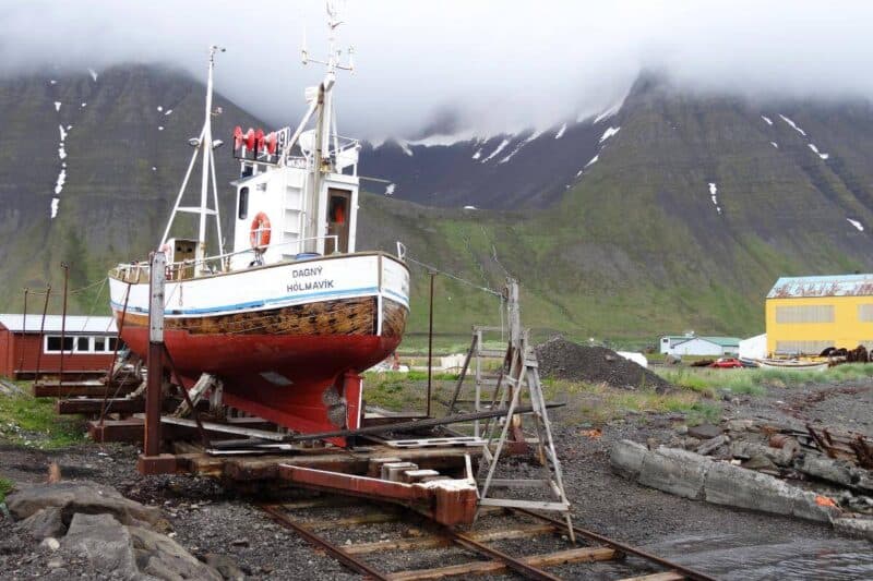 Kleines, aufgebocktes Fischerboot im Hafen von Ísafjörður 