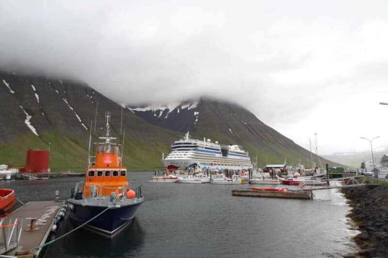 Das Hafenbecken von Ísafjörður mit steilen, schneebedeckten Felsen im Hintergrund