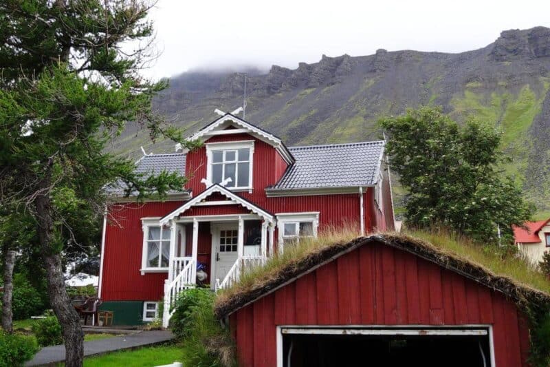 Rotes Holzhaus mit weißen Dachverzierungen im Stadtzentrum von Ísafjörður 