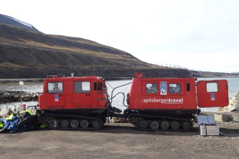 Ein rotes Kettenfahrzeug im Hafen von Spitzbergen