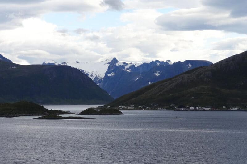 Schneebedeckte Berge und kleine Felsinseln in den norwegischen Fjorden vor Tromsø