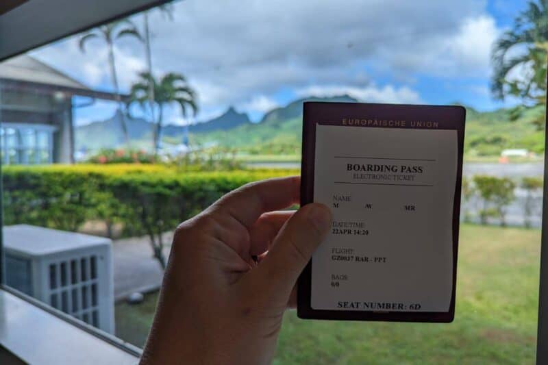 Reisepass und Bordkarte mit den Bergen von Rarotonga im Hintergrund