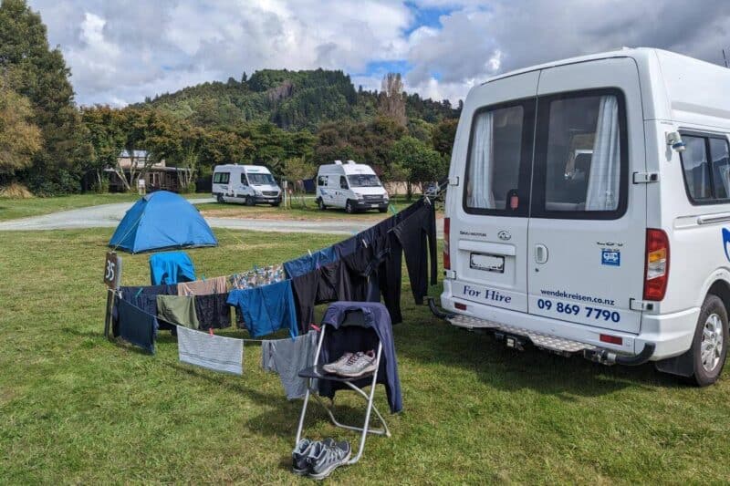 Zwischen unserem Campervan und der Stellplatzmarkierung kreuz und quer aufgespannte Wäscheleine auf einem Campingplatz in Neuseeland