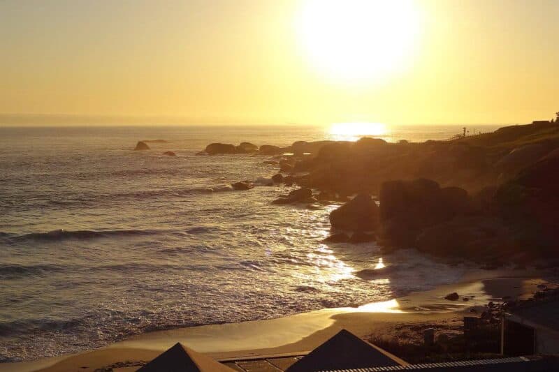 Sonnenuntergang über den Klippen eines Sandstrands in Clifton