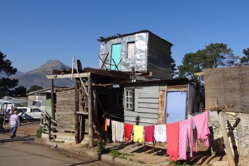Zweistöckige Wellblechhütte mit aufgespannter Wäscheleine in der Township Kayamandi in Stellenbosch