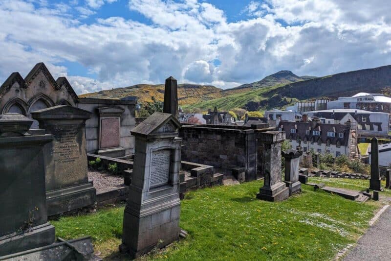 Grabsteine im New Calton Burial Ground mit den Hügeln des Arthur's Seat im Hintergrund